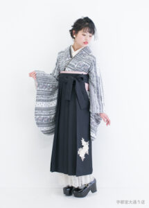 卒業袴：ゴシックでガーリーな雰囲気のコーディネートを着用して伏目で袖を広げる女性