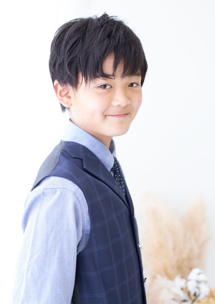 ハーフ成人：朗らかに微笑む、ブルーのスーツを着た10才の男の子