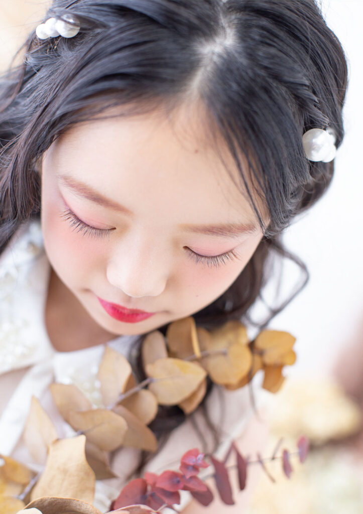 ハーフ成人：パールの髪飾りに長いまつ毛が特徴的な10才の女の子