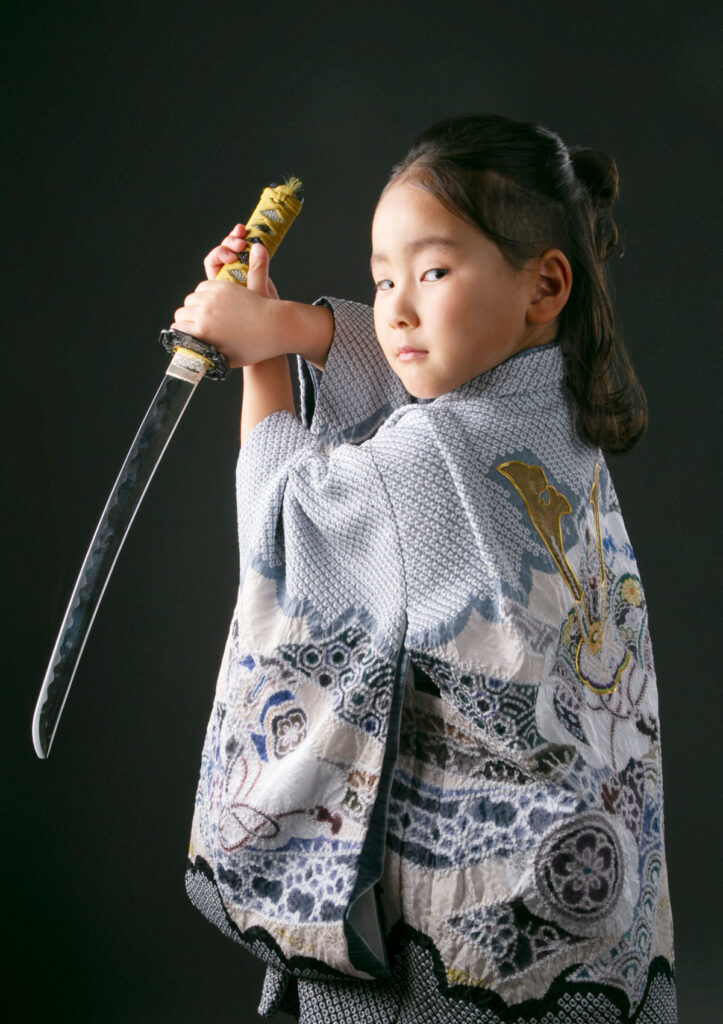 U2025-5model_753 七五三:総絞り風の羽織袴に刀を持ちポージングをする5歳の男の子