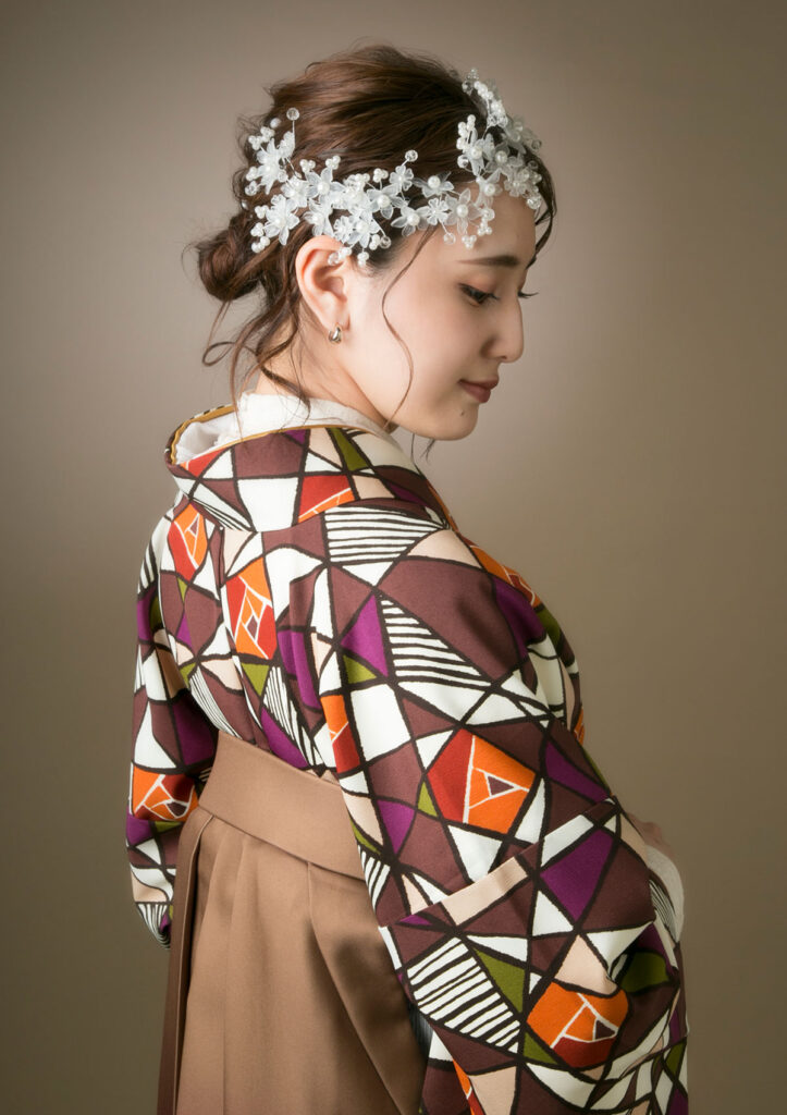 卒業袴：個性的なステンドグラス風の着物と繊細な髪飾りを付けた女性