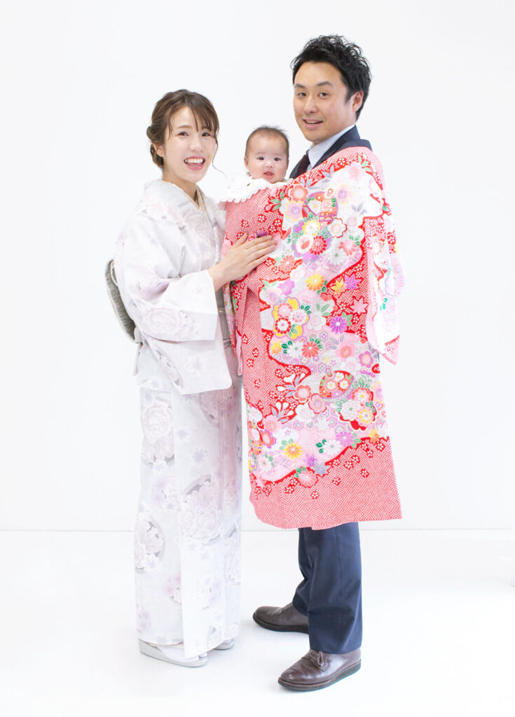 家族衣装：お宮参りのお祝いに淡い上品な色合いの訪問着とスーツを着用している家族