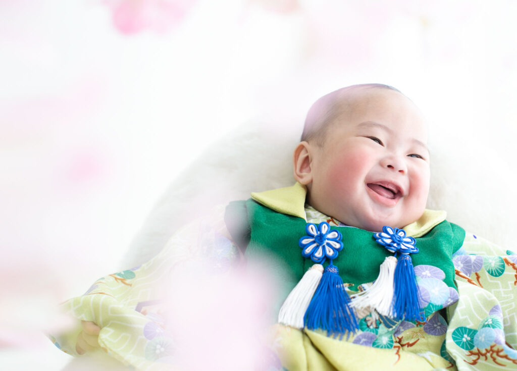 お節句：緑色の着物を着て微笑む男の子の赤ちゃん