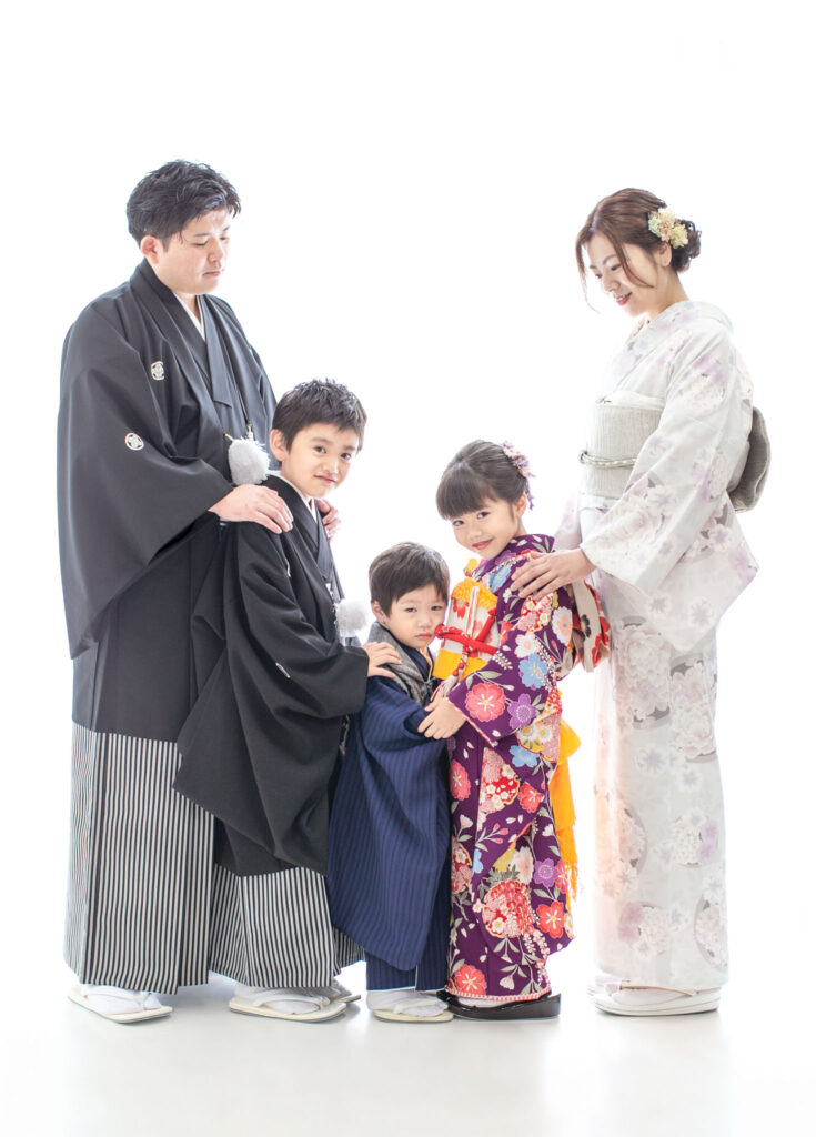 家族衣装：七五三の記念に全員で着物を着て、向かい合って見つめ合う家族