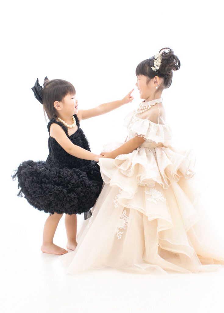 家族衣装：かわいくじゃれあう、正反対の色味のドレスを着た姉妹