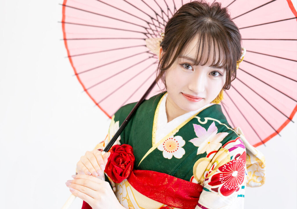 成人式：和傘を持って、深緑の振袖を着用した女性