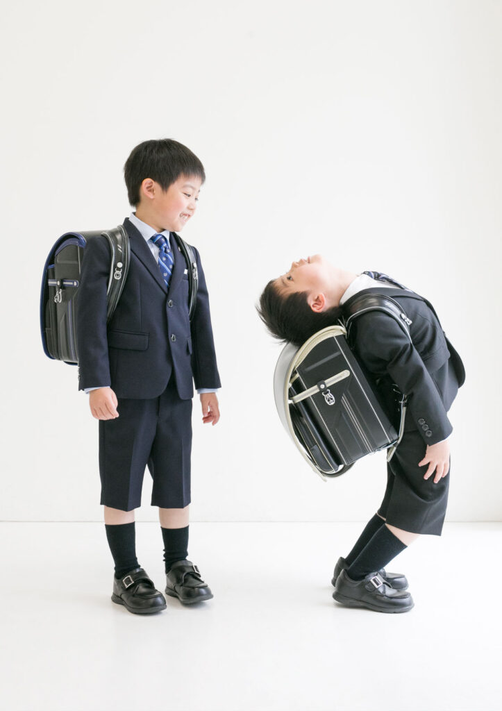 入学：黒いランドセルを背負って面白いポーズをする男の子とそれを見て笑う男の子