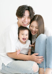 ベビー・バースデー：パパとママがぎゅっと寄り添い嬉しそうに笑う女の子