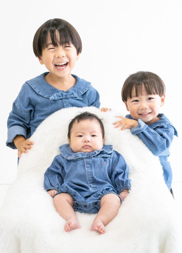 お宮参り：兄弟おそろいのデニム衣装を着て楽しそうに笑う三兄弟