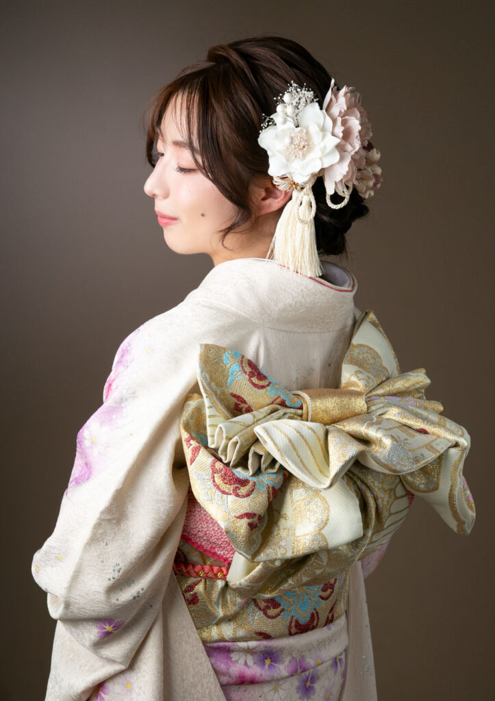 成人式：まるでリボンのような美しい手結びの帯がよく見えるポージングをした女性