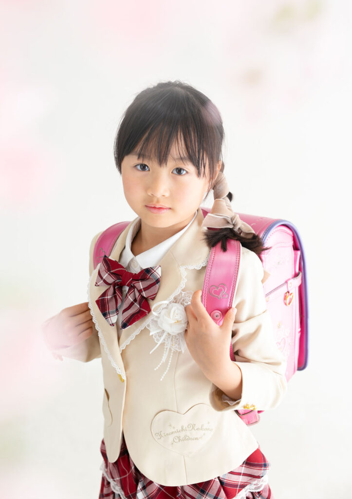 入学：キュートなピンクのランドセルを背負ってアイドルの様な服を着た女の子