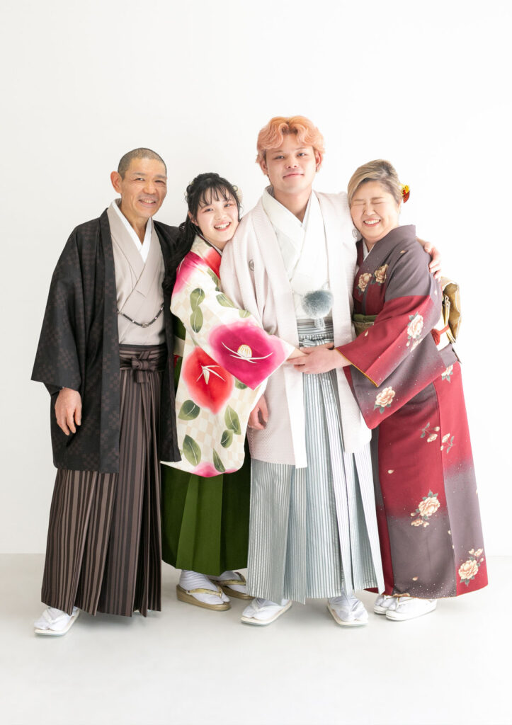 家族衣装：成人の記念に訪問着や袴を着て、主役の男性に思い切りハグをする家族