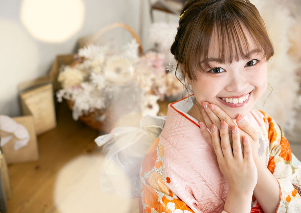 成人式：キラキラ光るライトと共に綺麗なネイルが良く見えるポーズをした振袖を着た女性