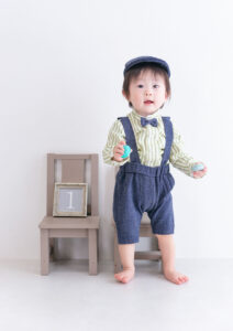 ベビー・バースデー：デニム風でサスペンダー付きの接アップを着た１歳の男の子