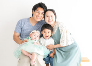 ベビー・バースデー：パパとママ、おにいちゃんに囲まれるドレスを着た女の子