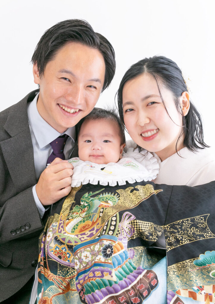 お宮参り：男の子用の黒い産着を着た赤ちゃんとパパママ