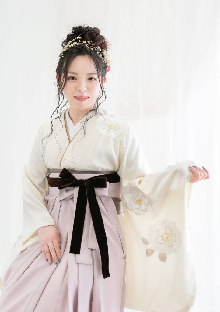 卒業袴：フェミニンな雰囲気のコーディネートを片袖を広げてポージングする女性