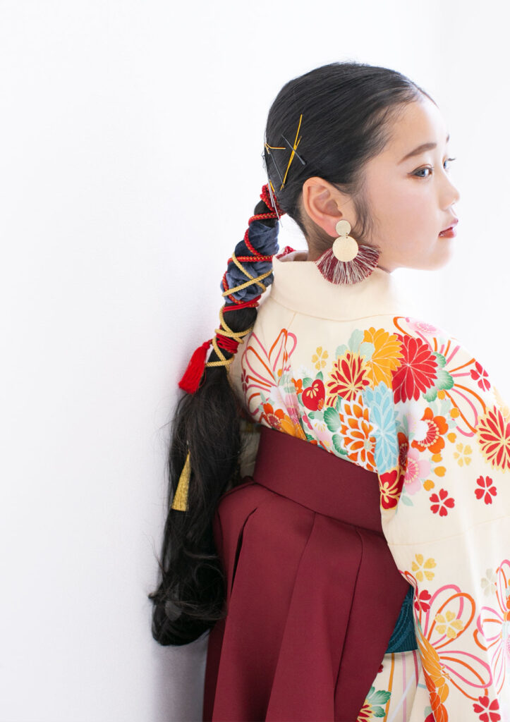 ハーフ成人：個性的でおしゃれなヘアスタイルで袴を着た 10才の女の子