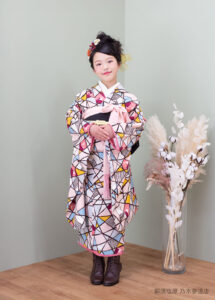 10歳着物：水色とピンクの幾何学柄のモダンな着物を着た10才の女の子。