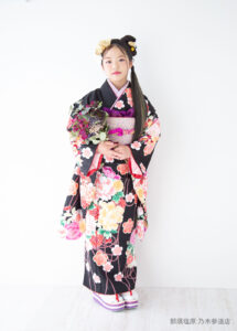10歳着物：黒い花柄の古典的な着物を着た10才の女の子。