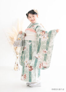 10歳着物：くすみグリーンのボタニカル柄のオシャレな着物を着た10才の女の子。