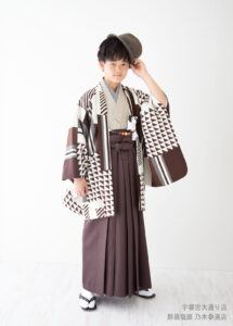 10歳着物：ブラウンの幾何学模様のモダンな着物を着た10才の男の子。