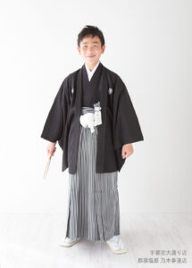 10歳ハーフ成人着物：古典的な黒紋付きの着物を着た10歳の男の子。