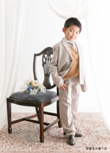 10歳ハーフ成人スーツ：ベージュのストライプのスーツを着た10歳の男の子。