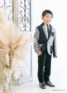 10歳ハーフ成人スーツ：グレーとブラックの切り替えしのスーツを着た10歳の男の子。