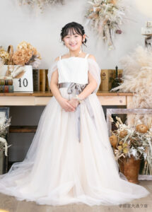10歳ドレス：淡いベージュのチュールドレスを着た10才の女の子。