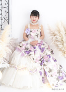 10歳ドレス：紫の花柄のドレスを着た10才の女の子。