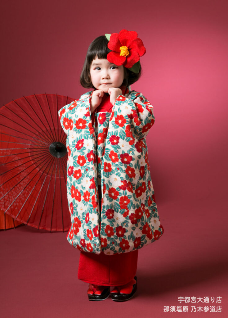 七五三3歳着物：赤い椿柄の着物を着た3才の女の子。