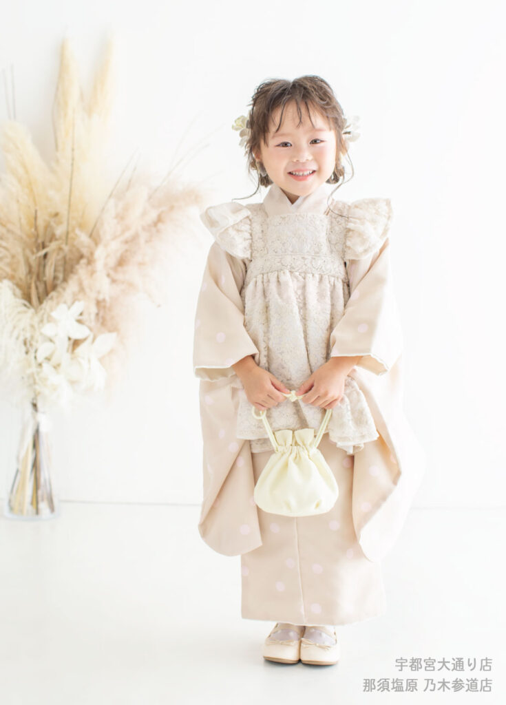 七五三３歳着物：レースがふんだんにあしらわれた被布の着物を着た３才の女の子。