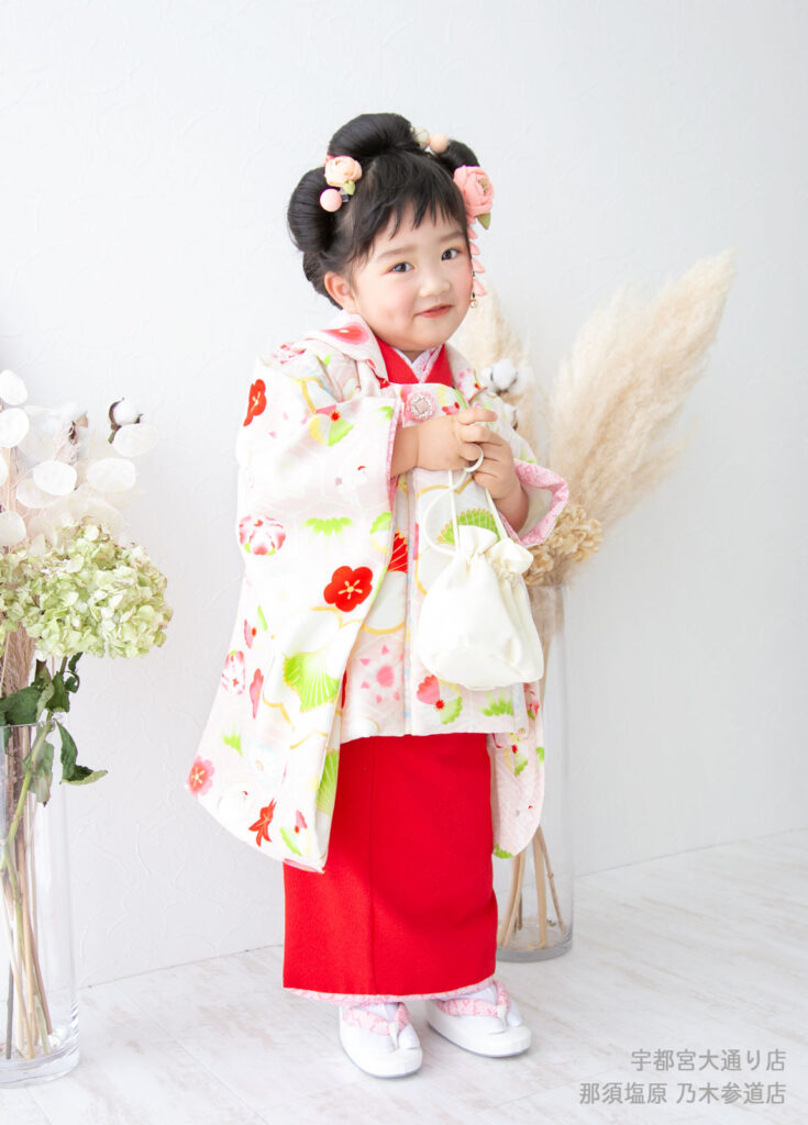 七五三３歳着物：梅柄の被布がかわいい、個性的な髪型をした３才の女の子。