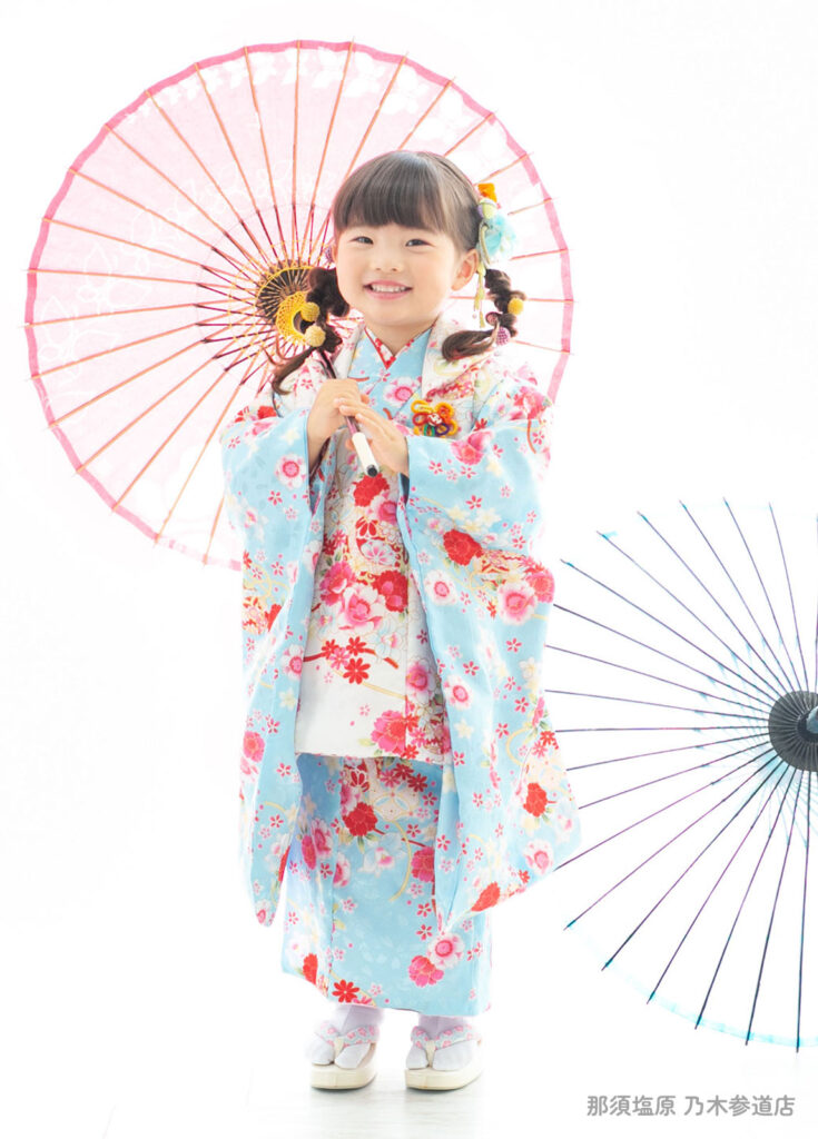 七五三３歳着物：大人気の水色に赤い花がたくさん散りばめられた着物を着た３才の女の子。