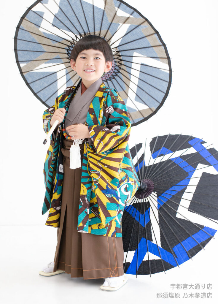 七五三５歳着物：ブルドーザーやステゴザウルス、プテラノドン、ショベルカーなど、男の子が大好きな物がたくさんい描かれた着物を着た５才の男の子。