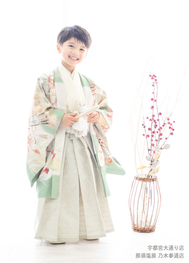 七五三５歳着物：鶯色の日本的な柄の着物をきた笑顔の５才の男の子。