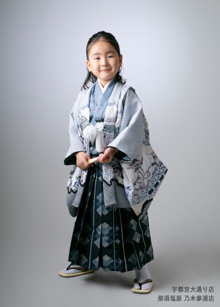 七五三５歳着物：しぼり柄の最新の着物を着て扇子を持つ５才の男の子。
