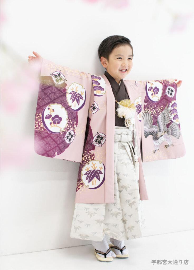 七五三５歳着物：くすみピンクの着物を着て両手を広げる５才の男の子。
