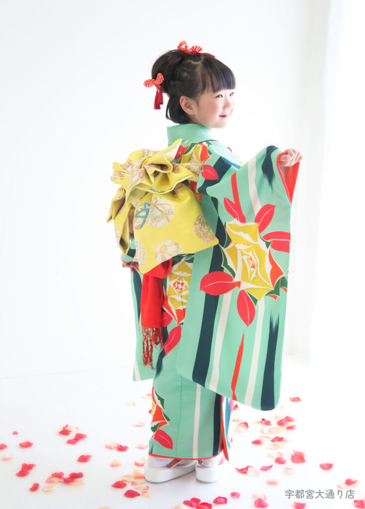 七五三７歳：エメラルドグリーンに赤いバラ柄の着物を着た７才の女の子。