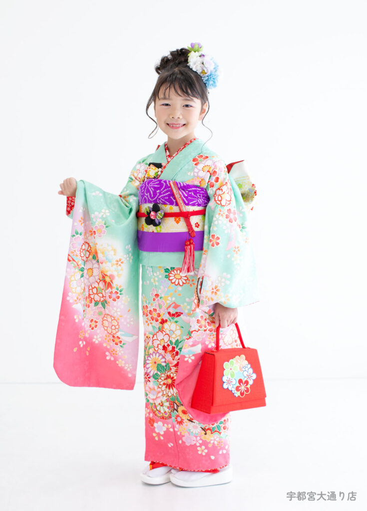 七五三７歳着物：人気のエメラルドグリーンとピンクのグラデーションの着物を着た7歳の女の子。