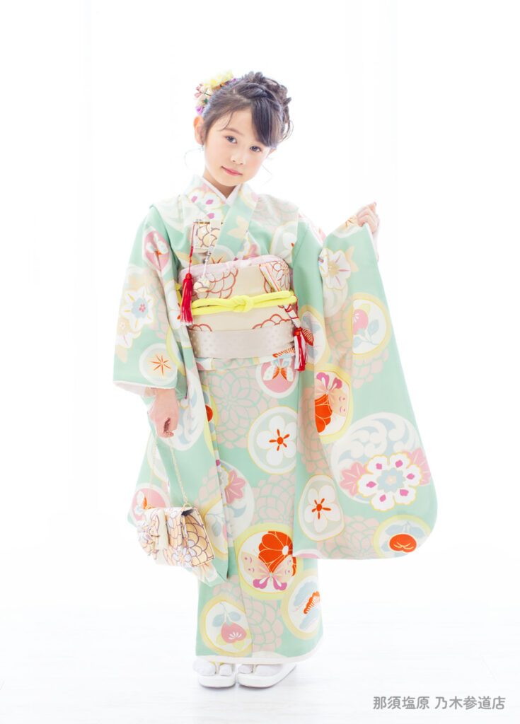 七五三７歳着物：淡いくすみエメラルド色の着物を着た7歳の女の子。