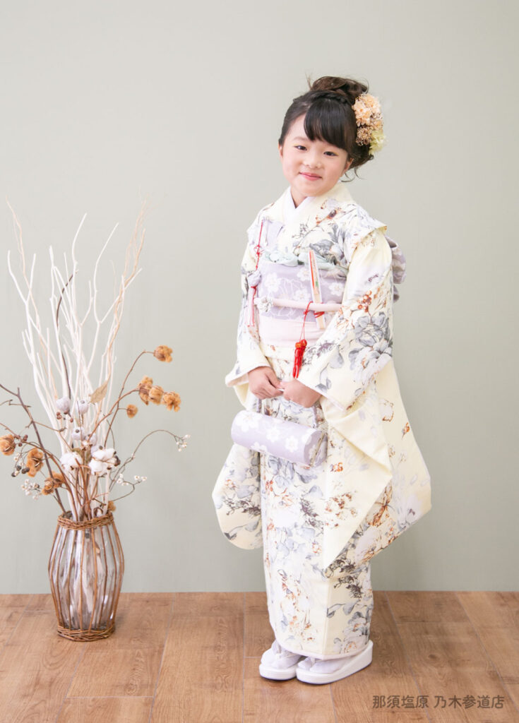 七五三７歳着物：シュガーケイのボタニカル柄のクリーム色の着物を着た7歳の女の子。