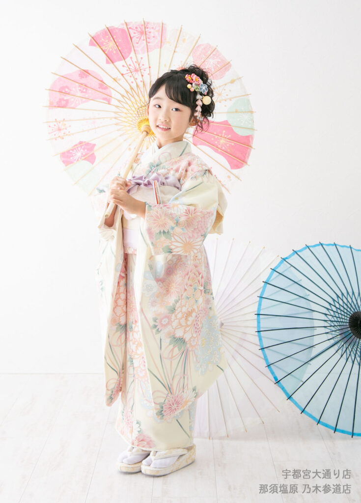 七五三７歳着物：クリーム色の淡い花柄の着物を着た７才の女の子。