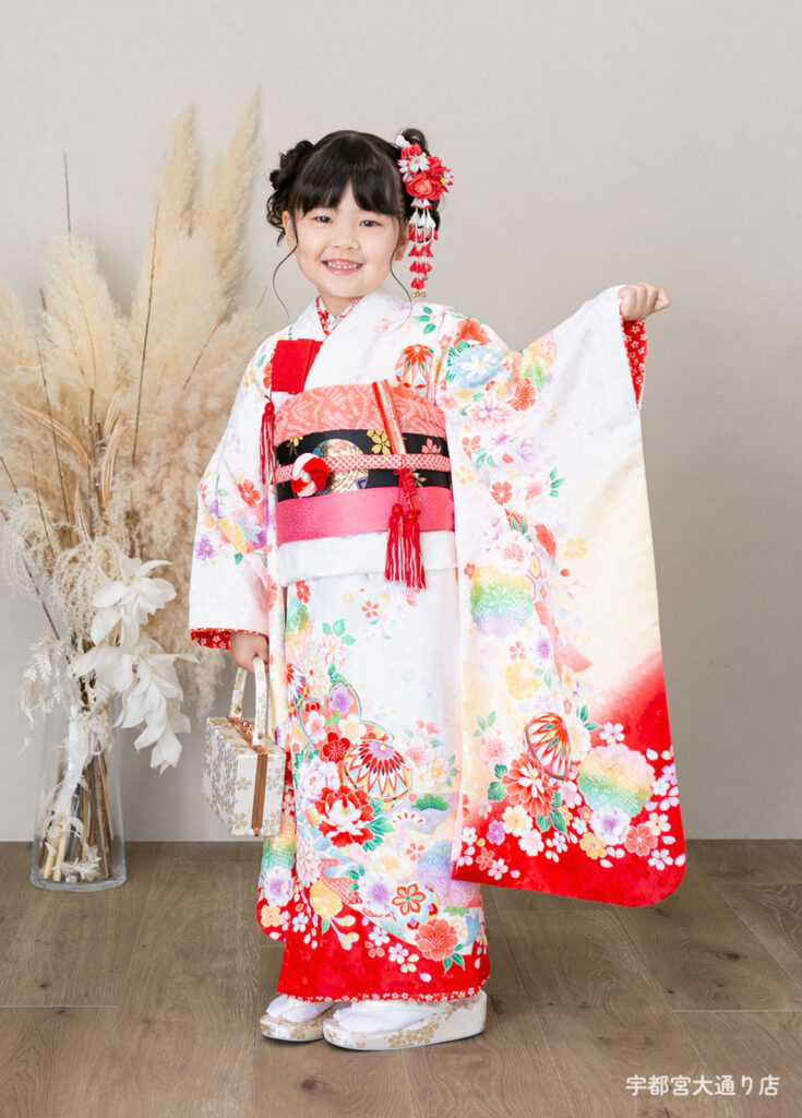 七五三７歳着物：白に赤い毬模様が入った着物を着た７歳の女の子。