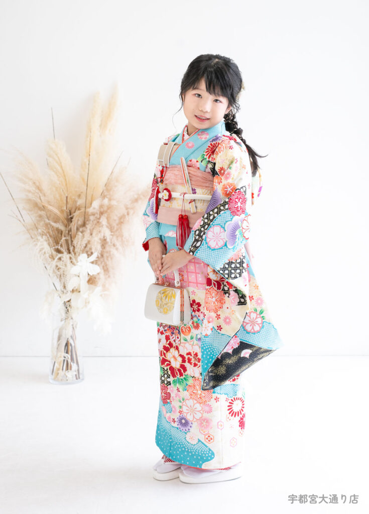 七五三７歳着物：水色の絞りデザインの豪華な着物姿の7歳の女の子。