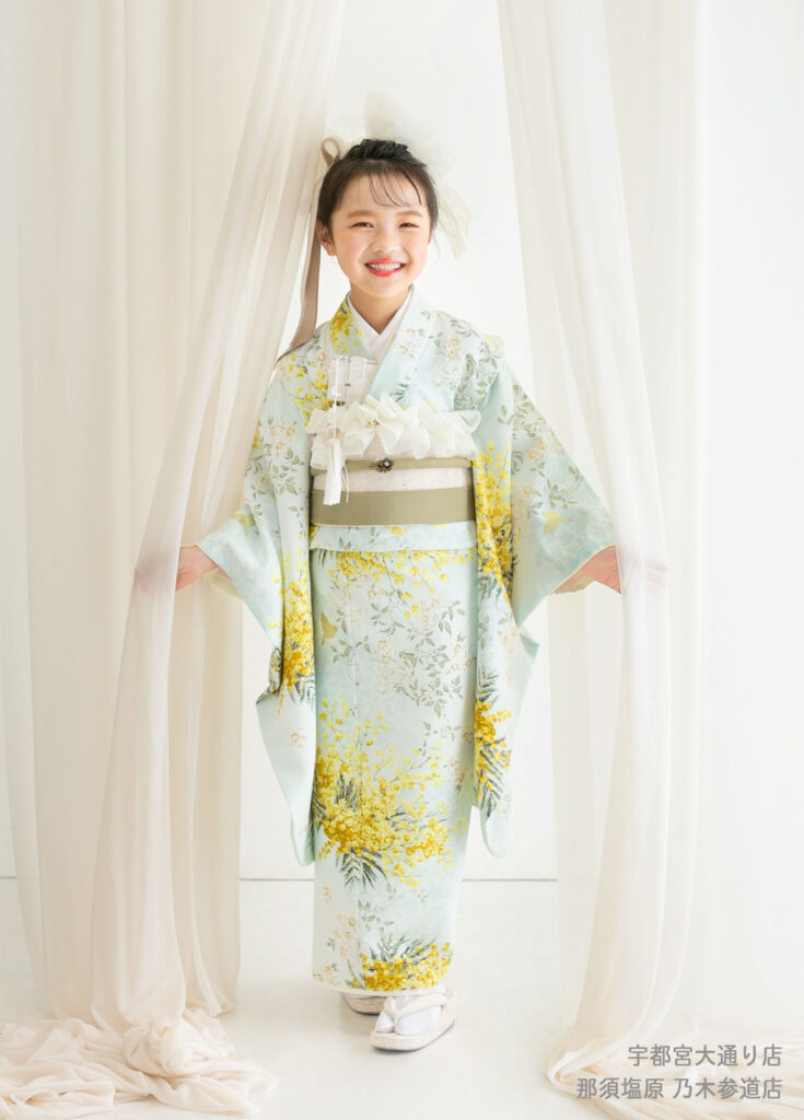 七五三７歳着物：ミモザ柄のトレンドの着物を着た7歳の女の子。