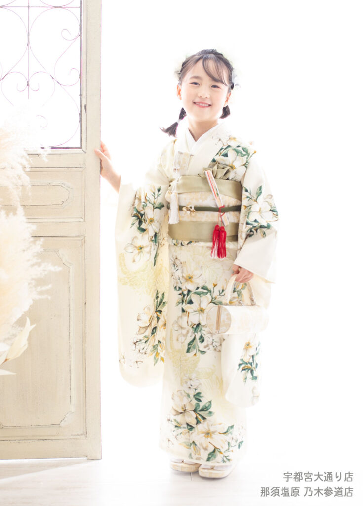 七五三７歳着物：百合が描かれた白い着物を着た7歳の女の子。