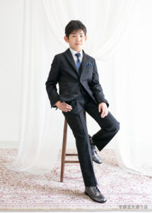 10歳ハーフ成人スーツ：濃紺の格子柄のスーツを着た10歳の男の子。