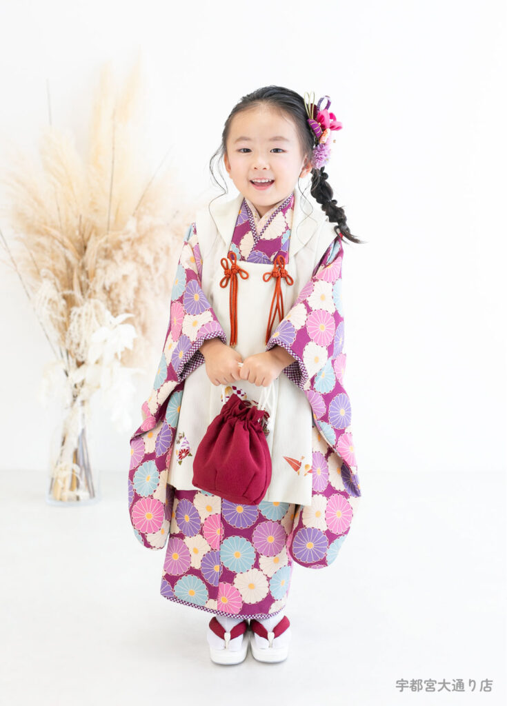 七五三３歳着物：大正ロマン風の紫色の菊模様の着物を着た３歳の女の子。